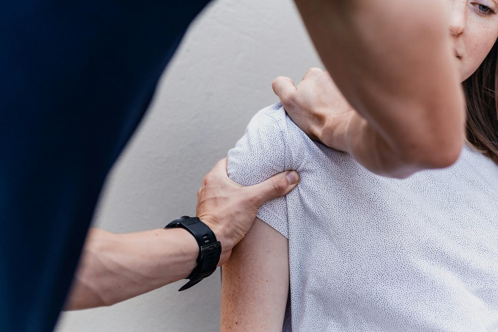 Therapeutin behandelt die Schulter einer Patientin